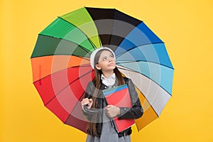 happy girl in glasses hold notebook. education. teen child under colorful parasol.