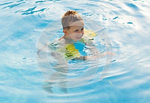 Happy girl with goggles in swimming pool