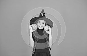Happy girl on Halloween wear witch carnival costume indoor holding pumpkin, halloween party
