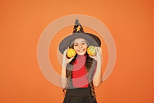 Happy girl on Halloween wear witch carnival costume indoor holding pumpkin, halloween party