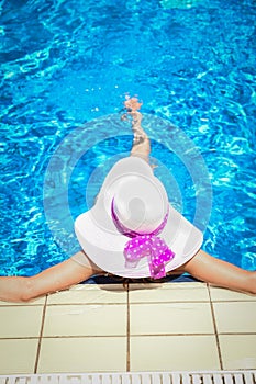 happy girl in a hat by the pool on the nature of the sea shore