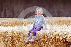 Happy girl having fun with hay on a farm