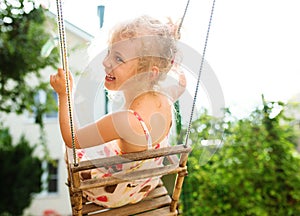 Happy girl having fun on a swing
