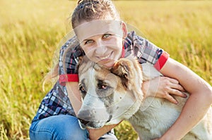 Happy girl with her dog Central Asian Shepherd in rural areas in