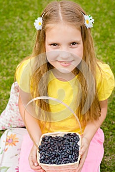 Happy girl holding basket with berry