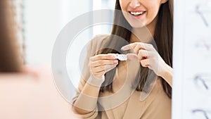 Happy girl holding contact eye lenses and container