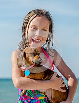 Happy girl holding dachshund