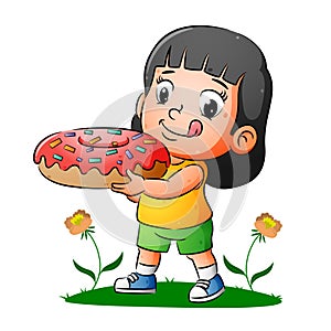 The happy girl is holding the delicious donuts with colorfull messes