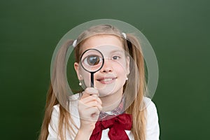 Happy girl holding on eye magnifying glass loupe