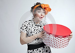Happy girl holding gift box with red polka dots