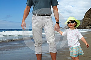 Happy girl holding man's hand on a beach
