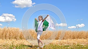 Happy girl holding Pakistan flag dancing outdoor under sunny sky. Smiling free proud independent patriotic Afro