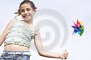 Happy Girl Holding Pinwheel Against Clear Sky