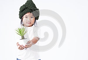 Happy girl holding  plant in her hand on white background