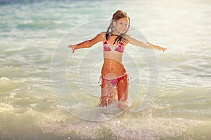Happy girl jump on the sea waves