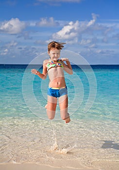 Happy girl jumping on the beach