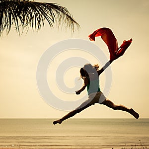 Happy girl jumping on the beach