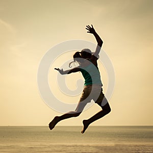 Happy girl jumping on the beach on the day time