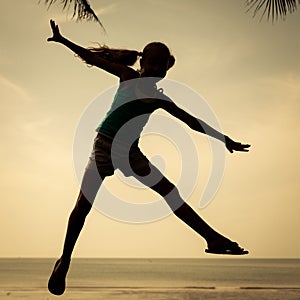 Happy girl jumping on the beach on the day time