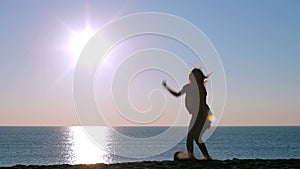 Happy girl jumping on the beach at sunrise