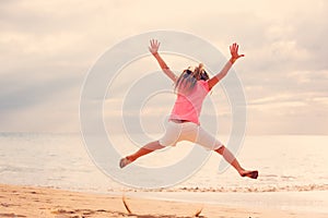 Happy Girl Jumping on the Beach at Sunset