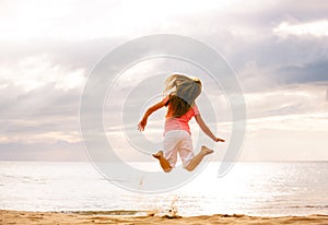 Happy Girl Jumping on the Beach at Sunset