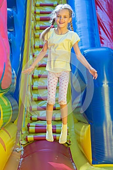 Happy girl jumping on inflatable trampoline