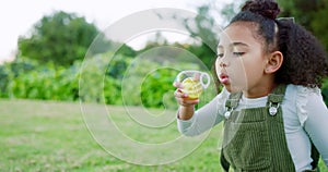 Happy girl kid blowing soap bubbles in park, garden and nature for playful fun, joy and childhood development, growth