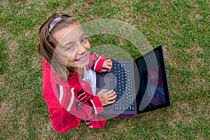 Happy girl with laptop smiling outdoor photo