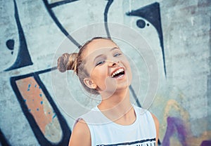 Happy girl laughing against a colorful graffiti, graphiti background. Concept of joy and happiness photo