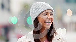 Happy girl laughing and looking joyful with bokeh lights in winter. Portrait of a cute young woman smiling, enjoying a