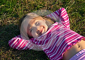 Happy girl laying on a grass