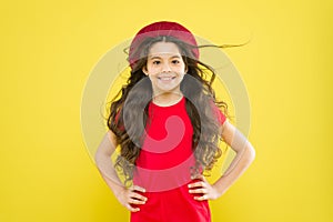 Happy girl with long curly hair in beret. little girl in french style hat. summer fashion and beauty. childhood