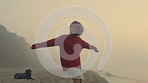 Happy girl looking at camera. Fashionable woman posing on beach at sunrise