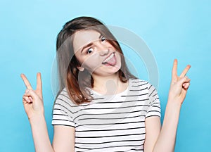 Happy girl  looking at camera with smile and showing peace sign with fingers