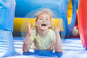 Happy girl lying on big inflatable trampoline game