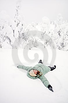 Happy girl lying down on snow