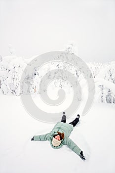 Happy girl lying down on snow