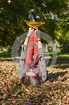 Happy girl lying on yellow autumn leaves
