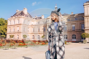 Happy girl in a mikimaus hat in the Luxembourg garden and the Palace in Paris