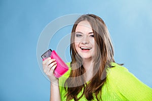 Happy girl with mobile phone in pink cover