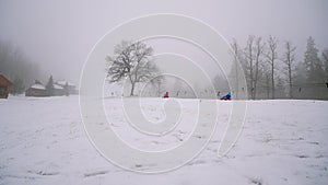 Happy girl and mother rides snowtube on snowy roads