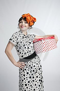 Happy girl opening gift box with red polka dots