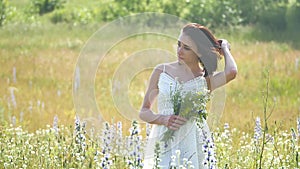 Happy girl outdoor in a field with flowers in nature. girl in a field smiling woman holding a bouquet of flowers