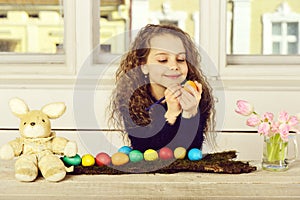 Happy girl painter, rabbit toy, pencil, tulip flowers, easter eggs