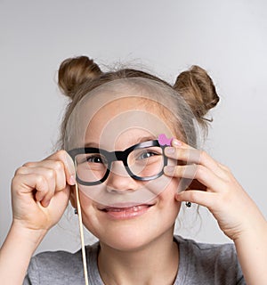 Happy girl in paper eyeglasses mask studio portrait