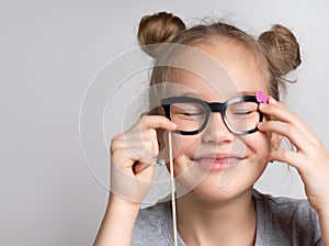 Happy girl in paper eyeglasses mask studio portrait