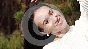 Happy girl in the Park sitting on a bench, young woman, with phone, long brunette hair.