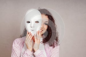 Happy girl peeking behind mask