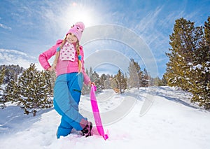 Happy girl in pink standing with sled